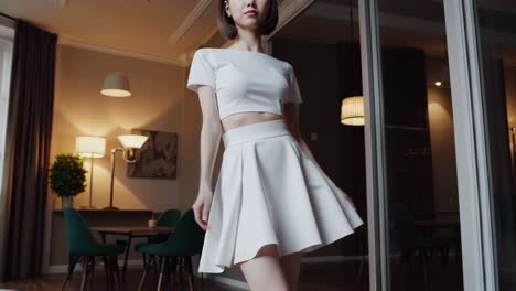 young woman in white crop top and skirt