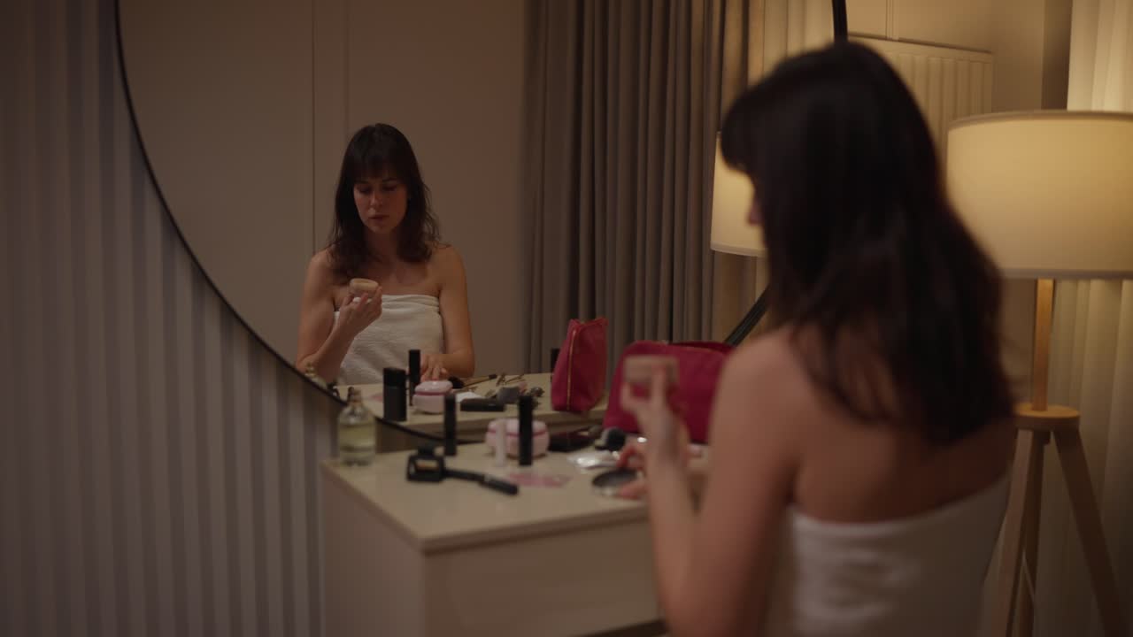 mujer haciendo maquillaje delante de un espejo