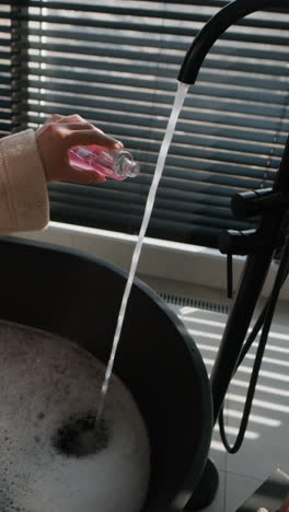 Woman pouring liquid into a bathtub