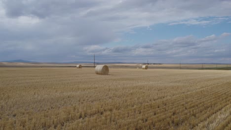 Silageheuballen-Am-Schönen-Großen-Himmel,-Landwirtschaftliches-Ackerland-In-Montana---Luftdrohne