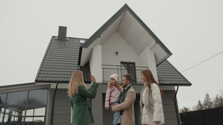 Immobilienmakler zeigt einer Familie ein Haus.