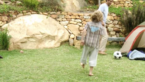 father and son playing football