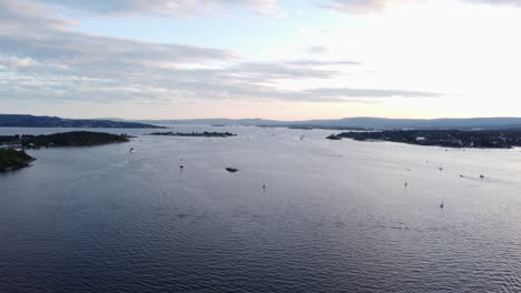 scandinavian fjord with small vessels, aerial view, golden hour