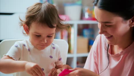a heartwarming moment: a young girl joyfully engages with her mother while admiring a small animal in a playful and nurturing environment