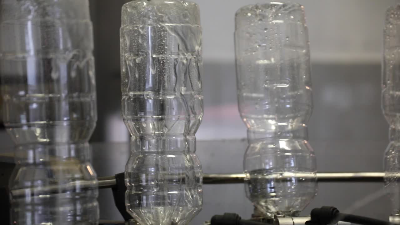 máquina automática de limpieza de botellas de plástico vacías boca abajo en una fábrica de vinagre con disparo de cerca