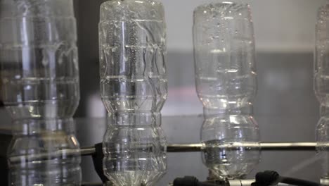 Automated-Machine-Cleaning-Empty-Plastic-Bottles-Upside-Down-at-a-Vinegar-Factory-with-Close-Up-Shot