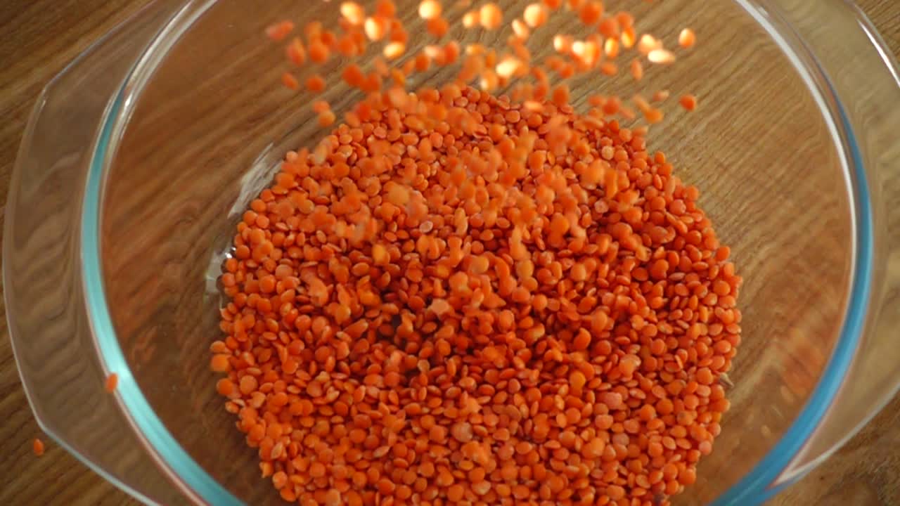 Røde linser fyldes i en glasform. Slowmotion