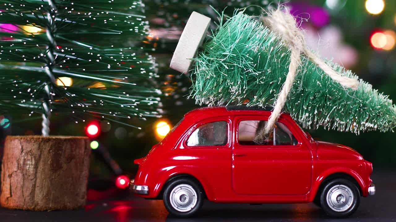 박이는 불빛과 지붕에 크리스마스 트리를 운반하는 빈티지 빨간 차와 함께 크리스마스 겨울 영상