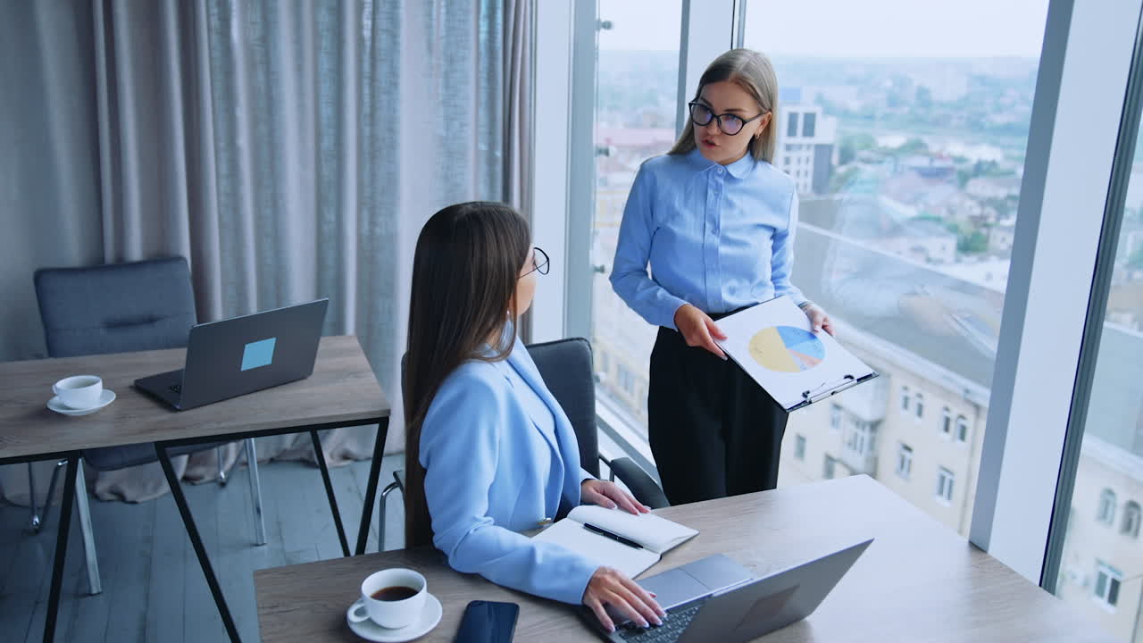 Businesswomen Discussing Data in Modern Office