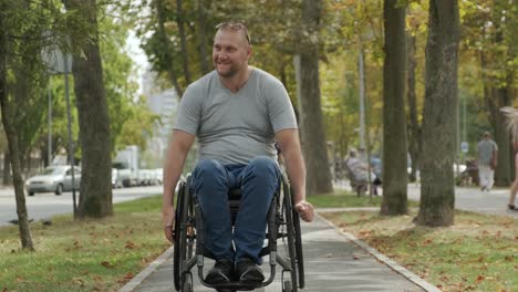 man with disabilities in wheelchair walk at the park alley