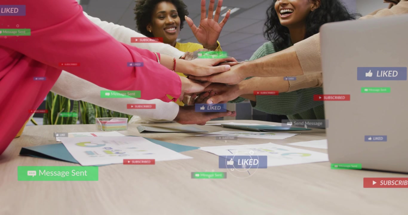 Team reaching in stacking palms to launch marketing push, laptop social overlays over hands