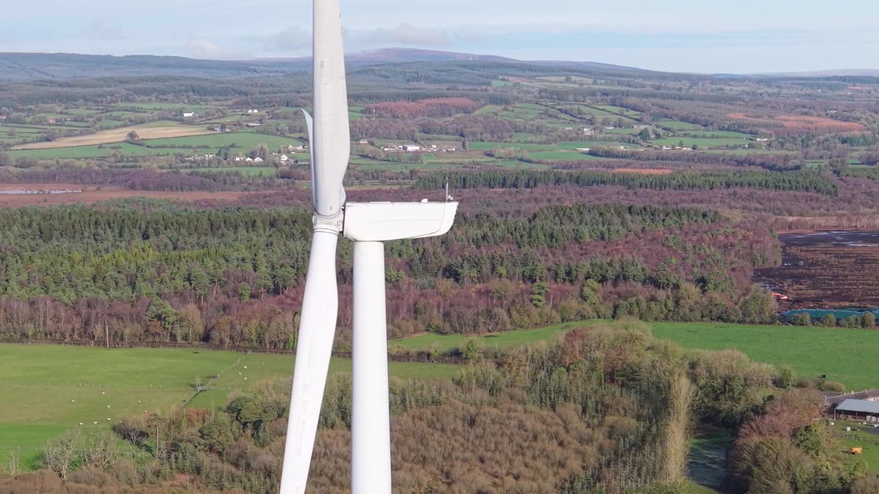 Le turbine eoliche girano su paesaggi verdi a Laois, Irlanda, producendo energia.