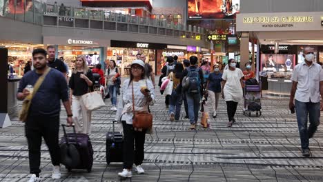 다양한 여행자들이 바쁜 공항 터미널을 항해합니다.