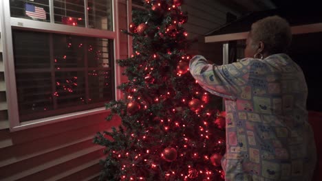 mujer negra decorando el árbol de navidad