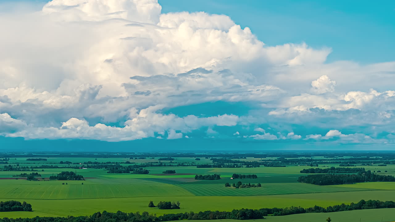 Wide flat rural landscape agricultural land under large white clouds horizon time lapse