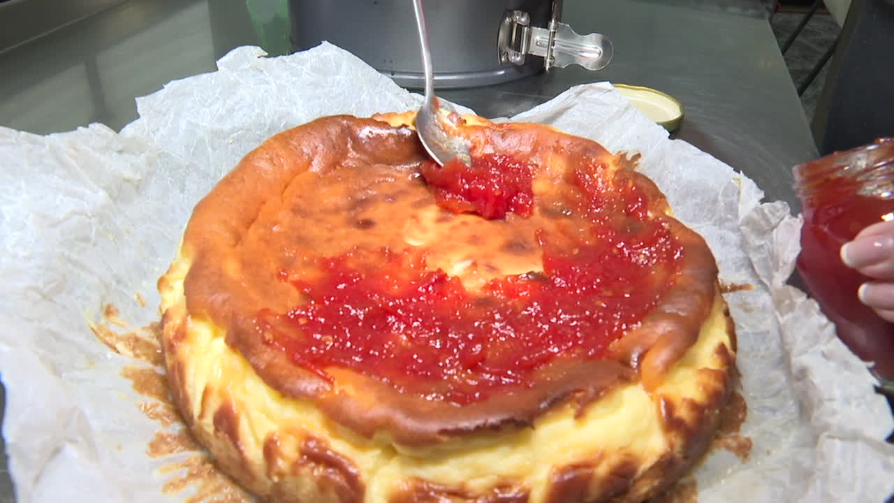 Woman preparing a cheesecake with tomato jam topping