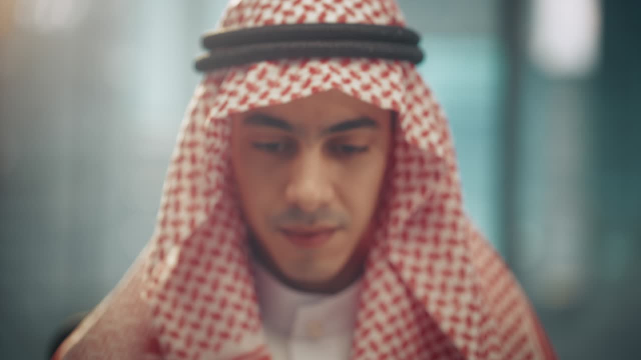 retrato de un joven empresario árabe exitoso en traje tradicional sonriendo suavemente, con kandura blanca y agal negro manteniendo un ghutra en su lugar. concepto de empresario árabe saudí, emiratí.