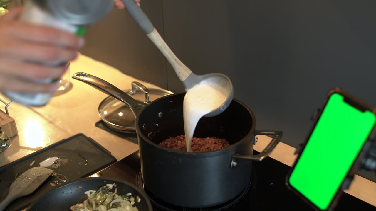 cerca de manos femeninas vertiendo leche enlatada en una cacerola