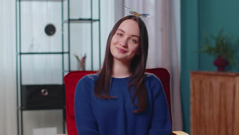 Portrait-of-happy-one-beautiful-teenager-student-girl-smiling,-looking-at-camera-at-home-on-chair