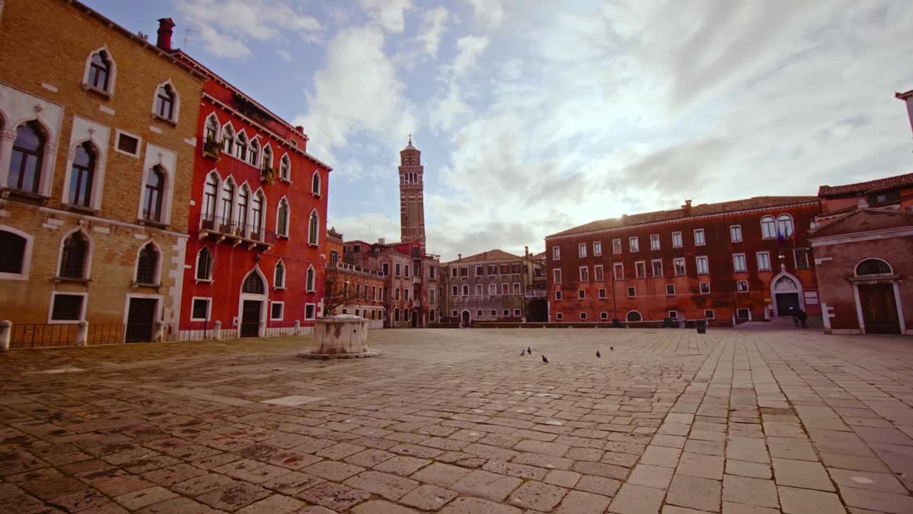 Piazza acciottolata tra bei edifici dai colori vivaci.