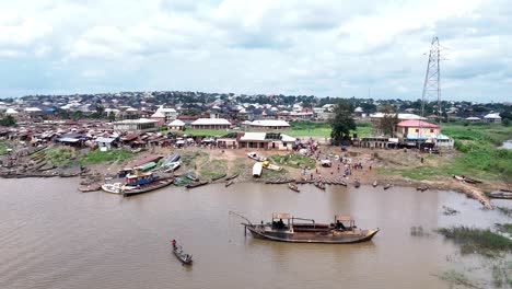 boats and dugout canoes in umueri or umuleri village on the anambra river in anambra state, nigeria - pullback aerial reveal