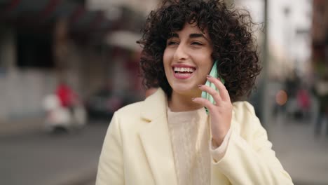 young woman smiling confident talking on the smartphone at street