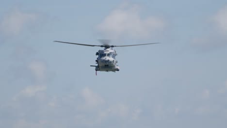 frontal view of military nh90 helicopter hovering and lowering hoist