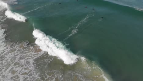 this super slow motion video shows a group of surfers in the ocean, one catching and riding a wave