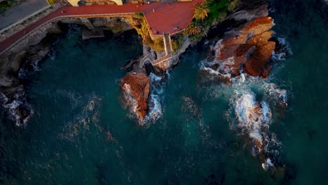 rocky coastline with waves crashing against rocks, genoa, italy, aerial view