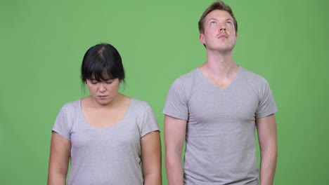 young multi-ethnic couple looking at opposite directions together