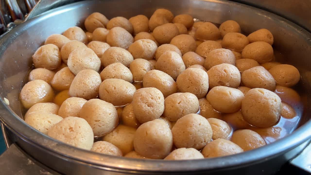 pedazos de roshogolla o rasgulla de gurer redondo en una tienda de dulces bengalí.