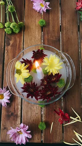 floating flowers and candle centerpiece on wooden table