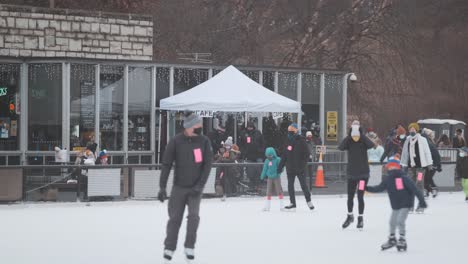 gimbal shot of people at outdoor ice rink cafe