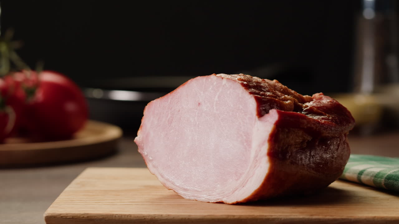 Woman holding a slice of ham on a cutting board