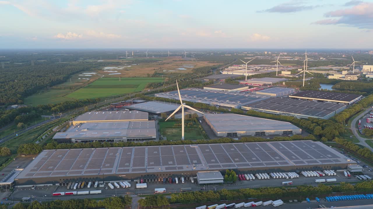 Aerial drone of Dutch distribution hubs with solar rooftops and wind turbines
