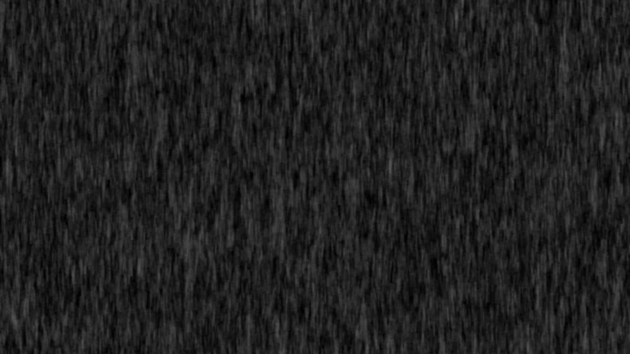 4k Heavy angled rain falling in front of the camera against black screen. Raindrops splashing. Rain closeup vfx insert. Practical seamlessly loopable footage. Heavy rainstorm hitting black surface.