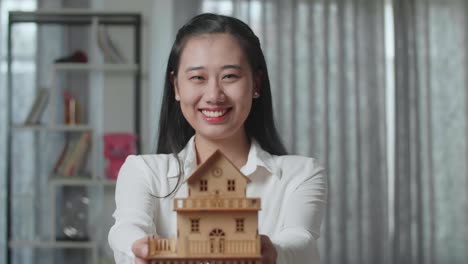 woman holding a model house