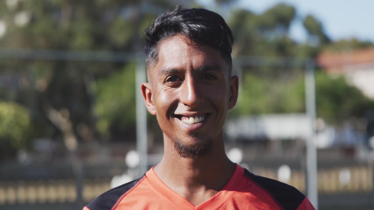 jugador de fútbol sonriendo a la cámara en el campo