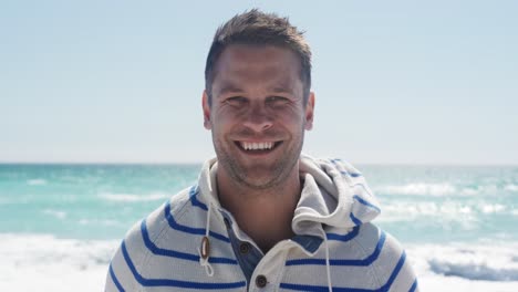 Man-standing-on-the-beach-and-looking-at-camera