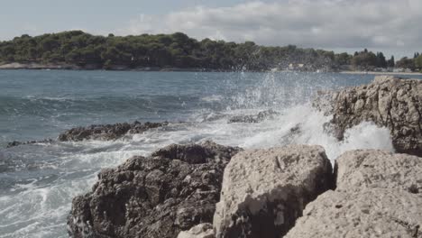 big ocean sea waves crashing on coastal rocks during beautiful sunny day in summertime