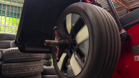 car wheel being rotated on a tire changer machine in a garage/workshop