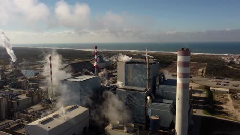 Cinematic-aerial-panoramic-view-of-polluted-factory-with-toxic-white-smoke-Industrial-pollution,-smokestack-exhaust-gases