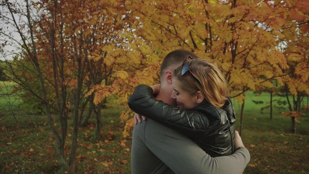 Coppia che si abbraccia in un parco autunnale.