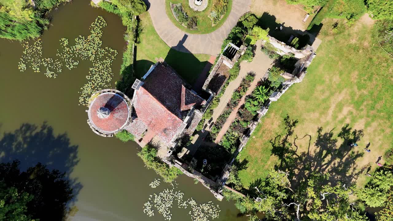 Birds eye view video of Scotney Castle, Kent, featuring romantic medieval ruins, landscaped gardens, and moat surrounded by countryside. Beautiful historic setting for film and editorial projects