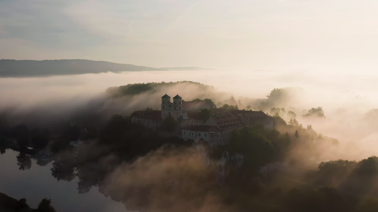 Aerial drone view of Benedictine Abbey over Vistula river in Tyniec in the morning fog, Krakow, Poland