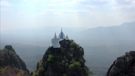 aerial view of thai temple in the sky with pagodas constructed on top of rocky mountains