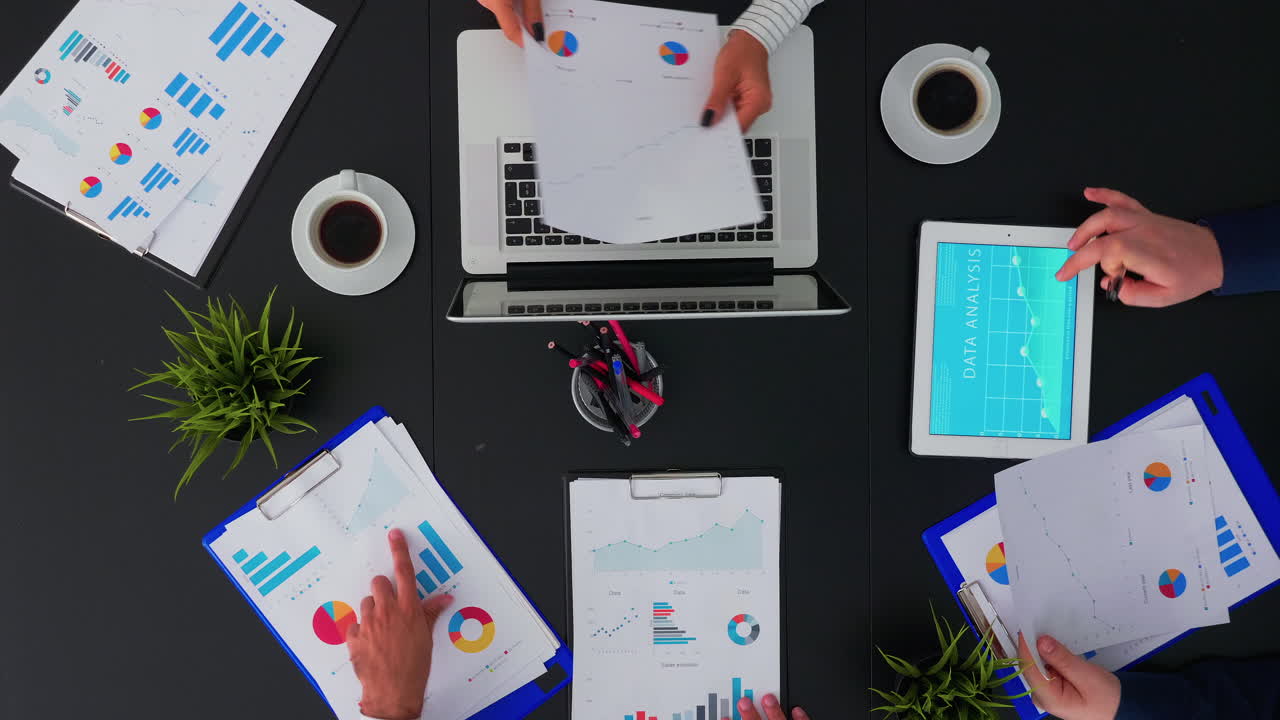 Persone che fanno brainstorming su grafici di statistiche finanziarie
