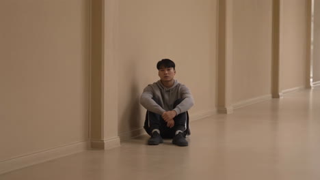 young man sitting alone in hallway
