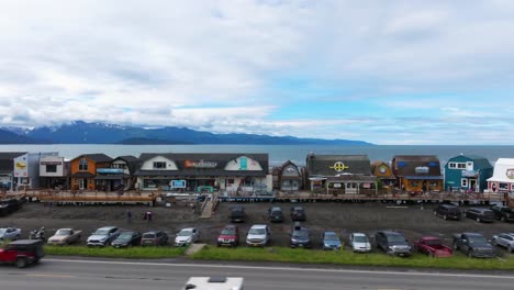 Dron-Aéreo-Panorámico-Por-Las-Tiendas-Costeras-De-La-Calle-Principal-En-El-Pueblo-Pesquero-De-Halibut-De-Homer,-Alaska