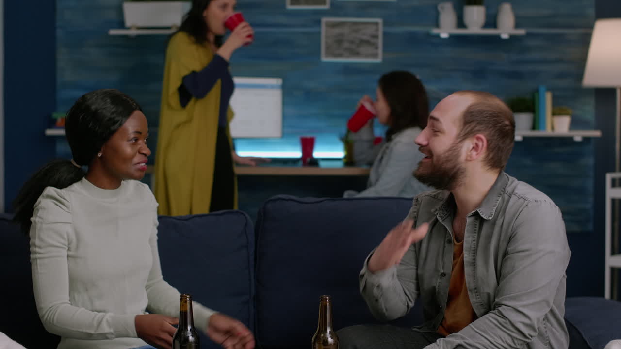 아프리카계 미국인 여성이 소파에서 휴식을 취하면서 남자 친구와 하이파이브를 하고 있습니다.